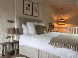 a bedroom with a large white bed and a lamp at Maison Père in Lagarde