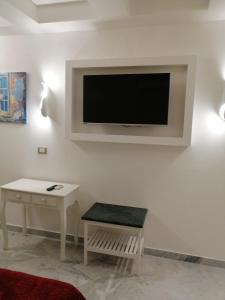 a living room with a flat screen tv on a wall at Federico 70 Giada Economy in Palermo