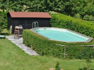 a swimming pool in a hedge next to a building at Snug Holiday Home in Chambourg Sur Indre with Pool in Chambourg-sur-Indre