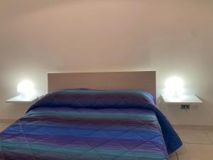 sypialnia z łóżkiem z dwoma lampkami na dwóch stołach w obiekcie Appartamento Residence Baia Blu w mieście Gallipoli