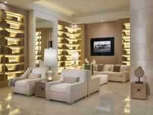 a living room with white furniture and a wall of shelves at Grand Beach Hotel Surfside in Miami Beach