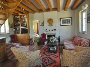 a living room with chairs and a couch and a table at Snug Holiday Home in Chambourg Sur Indre with Pool in Chambourg-sur-Indre