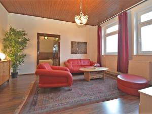 a living room with a red couch and a table at Villa with home cinema sauna in Treuen