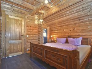 1 dormitorio con 1 cama en una cabaña de madera en Comfortable holiday home with hot tub, en Teunz