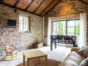 - un salon avec un mur en pierre et un canapé dans l'établissement Spacious Cottage with Private Garden in Ardennes, à Frahan