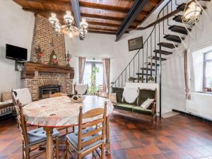 ein Esszimmer mit einem Tisch und einem Kamin in der Unterkunft Stunning Holiday Home in Oombergen with Terrace and Garden in Zottegem