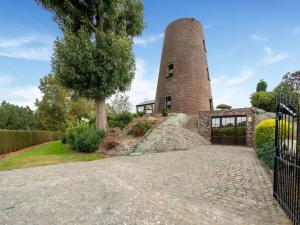 an external view of a brick building with a tower at Stunning Holiday Home in Oombergen with Terrace and Garden in Zottegem