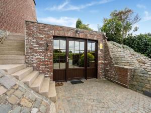 um edifício de tijolos com uma porta e algumas escadas em Stunning Holiday Home in Oombergen with Terrace and Garden em Zottegem