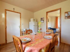 een eetkamer met een tafel met stoelen en een witte koelkast bij Cozy Holiday Home near the Forest in Bovigny in Gouvy