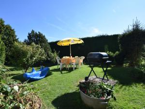 een achtertuin met een grill en een tafel met een barbecue bij Cozy Holiday Home near the Forest in Bovigny in Gouvy