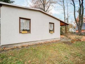 ein weißes Haus mit zwei Fenstern und einem Hof in der Unterkunft Holiday home with garden in Mahlow Brandenburg in Mahlow