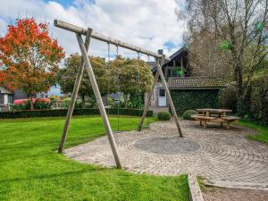 a park with a bench and a swing at Charming cottage with jacuzzi and sauna High Fens in Waimes