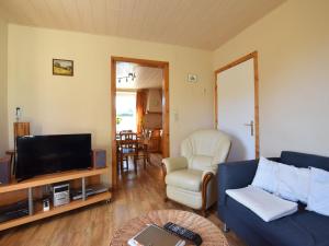 sala de estar con sofá azul y TV en Cozy Holiday Home near the Forest in Bovigny, en Gouvy