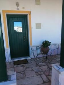 a green door of a building with a potted plant at Casas da Saibreira - nº10 in Elvas