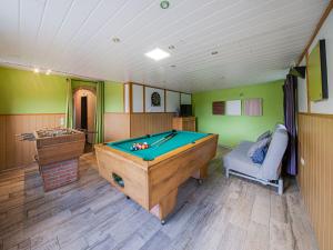 un tavolo da biliardo in una stanza con pareti verdi di Charming cottage with jacuzzi and sauna High Fens a Waimes