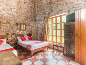 a bedroom with two beds and a window at Rancho Hotel El Carmen in Tlapacoyan