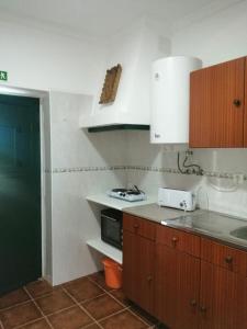 a kitchen with white cabinets and a stove top oven at Casas da Saibreira - nº10 in Elvas