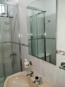 a bathroom with a sink and a shower with a mirror at Casas da Saibreira - nº10 in Elvas