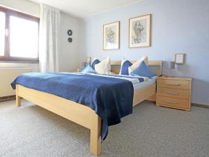 a bedroom with a bed with blue sheets and a window at Apartment with terrace in the garden in Pracht