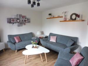 una sala de estar con 2 sofás azules y una mesa. en Apartment with terrace in the garden, en Pracht