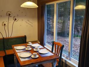 ディルセン・ストッケムにあるPeacefully chalet in Lanklaar with gardenの窓際のテーブル(カップ、ソーサー付)