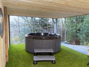 a large tub sitting on a lawn with a stool at Cosy Chalet in Odeigne with Jacuzzi in Manhay