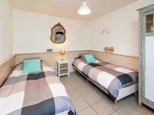 2 camas en una habitación con espejo en Tastefully furnished holiday residence located in the heart of the Ardennes, en Houffalize