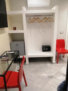 ein Wohnzimmer mit einem Tisch und einem roten Stuhl in der Unterkunft Federico 70 Rubino Family in Palermo