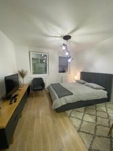 Dormitorio con cama, escritorio y TV en Sun Square Apartments, en Tuzla