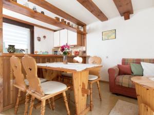 een keuken en een woonkamer met een houten tafel en stoelen bij Homey Chalet in Breitenbrunn Rittersgrun in Breitenbrunn