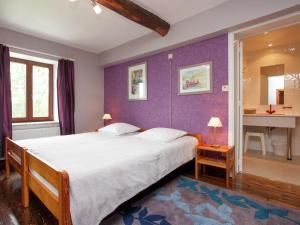 ein Schlafzimmer mit einem großen Bett mit lila Wänden in der Unterkunft Spacious Holiday Home in Humain with Garden in Marche-en-Famenne