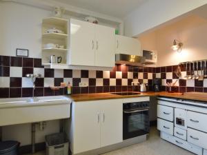 une cuisine avec des armoires blanches et du carrelage noir et blanc dans l'établissement Quietly located country house in Vielsalm, à Vielsalm