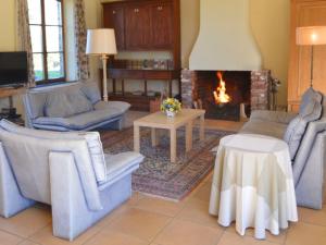 sala de estar con sofás y chimenea en Modern Cottage in Barvaux Condroz Amidst Meadows, en Barvaux-Condroz