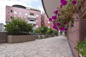 kamienny chodnik w mieście z fioletowymi kwiatami w obiekcie Appartamento Residence Baia Blu w mieście Gallipoli +7 zdjęć