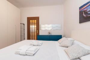 una camera da letto bianca con asciugamani bianchi su un letto bianco di Casa Samy - Sesto SG a due passi da Sesto Rondò - Battisti a Sesto San Giovanni