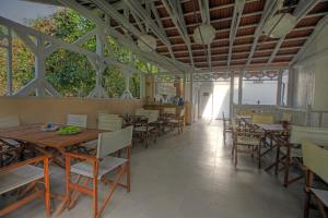a dining room with tables and chairs and trees at Vila Brancoveanu in Eforie Sud