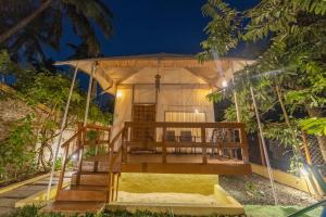 a swing house in a garden at night at Coconut Beach Farm in Alibaug