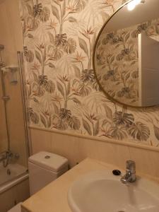 ein Badezimmer mit Waschbecken, Spiegel und Toilette in der Unterkunft Mi Capricho, Luxury Apartment in Mijas Costa