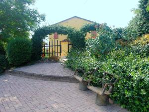 twee banken in een tuin met een gebouw bij Belvilla by OYO Massarella Due in Fucecchio