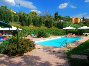 富切基奧的住宿－Belvilla by OYO Massarella Due，一个带遮阳伞的庭院内的游泳池