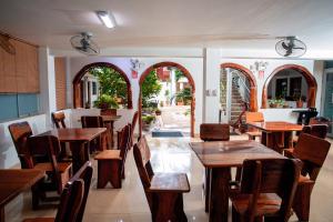 un restaurante con mesas y sillas de madera y ventanas en Hotel Principe I, en Puerto Maldonado