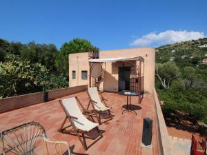 a patio with chairs and a table on a roof at Belvilla by OYO Torre in Ricadi