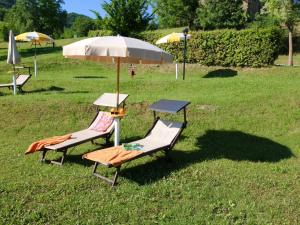 two chairs and an umbrella in the grass at Belvilla by OYO Rosa Rossa in Apecchio