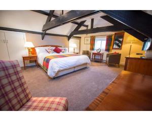 a bedroom with a bed and a chair in a room at Seven Stars in Dartmouth