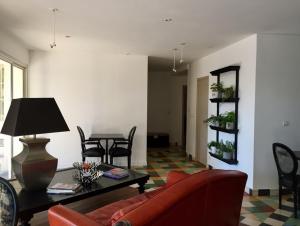 - un salon avec un canapé rouge et une table dans l'établissement Villa La Clarté, à Cavalaire-sur-Mer