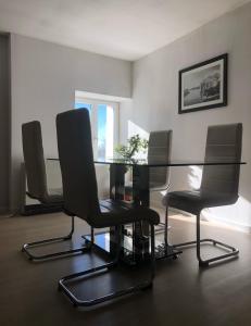 a dining room with a glass table and chairs at Gîtes de Chauvet in Gap