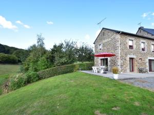 un edificio de piedra con una mesa de picnic delante de él en Cosy chalet with private garden in Normandy, en Isigny-le-Buat