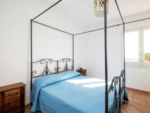 a bedroom with a black canopy bed with blue sheets at Pleasant Holiday Home in Santa Flavia in Santa Flavia