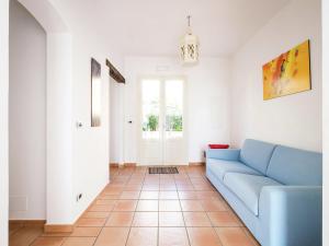 a living room with a blue couch and a tile floor at Pleasant Holiday Home in Santa Flavia in Santa Flavia