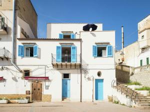 a white building with blue doors and windows at Pleasant Holiday Home in Santa Flavia in Santa Flavia